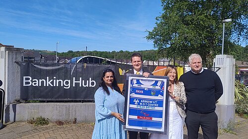 Outside the new banking hub, Jane Dodds MS, David Chadwick MP, Ams from the Temple Fish Bar and Steve from LINK holding up an Ystradgynlais rugby shirt