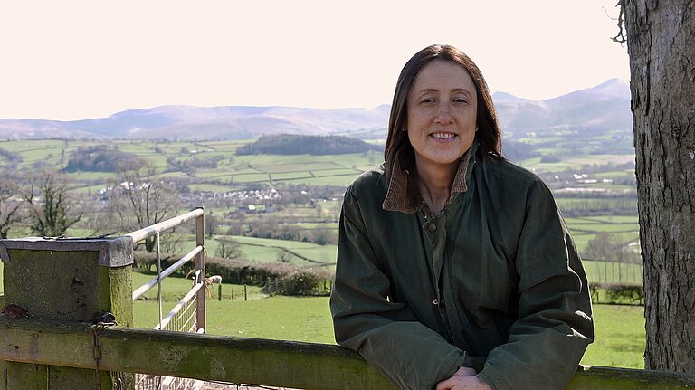 Jane leaning on a farm gate
