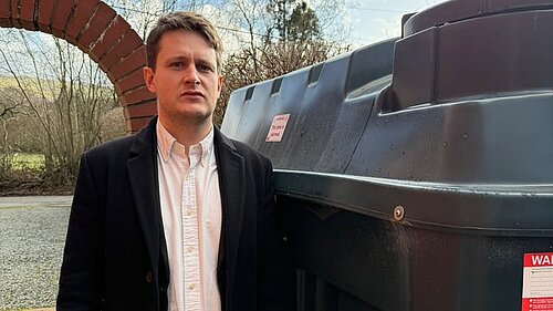 David Chadwick in front of heating oil tank