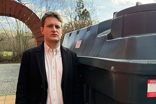 David Chadwick in front of heating oil tank